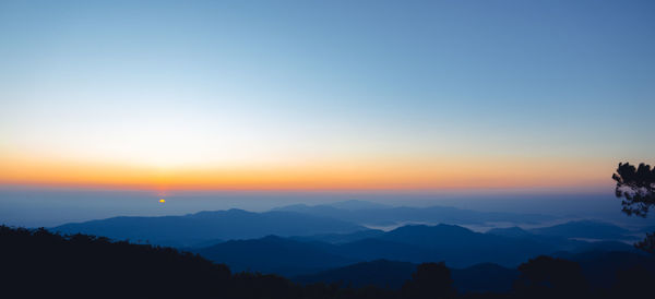 Scenic view of silhouette mountains against sky at sunset