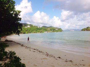 Scenic view of beach against cloudy sky