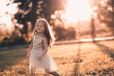 Portrait of cute girl standing at park