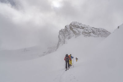 People skiing on snow covered landscape