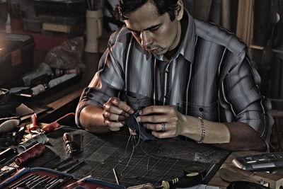 Man working with leather at table in workshop