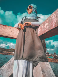 Woman wearing sunglasses standing against sky