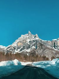 Scenic view of snowcapped mountains against clear blue sky