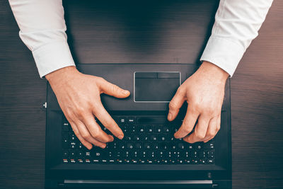 Midsection of man using laptop