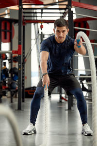 Portrait of young man exercising in gym