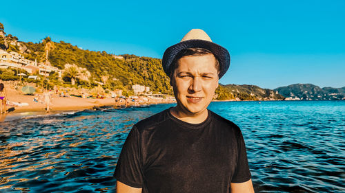 Portrait of young man standing against sea