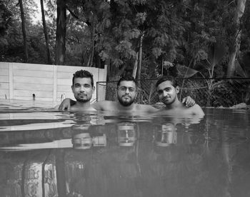 Portrait of shirtless friends swimming in lake