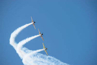 Low angle view of airplane flying against blue sky