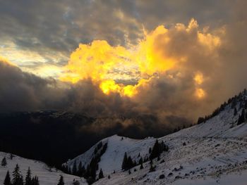 Snow covered mountains against cloudy sky
