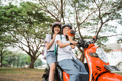 Side view of young woman riding motor scooter on field