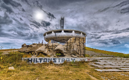 Abandoned buzludzha monument tower on field against sky
