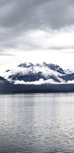 Scenic view of lake by snowcapped mountains against sky