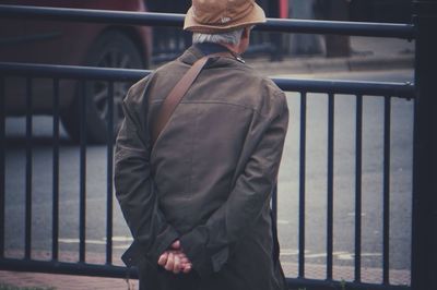 Rear view of man standing by railing