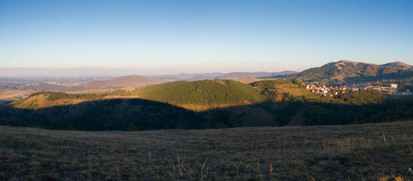 Scenic view of landscape and mountains against clear sky