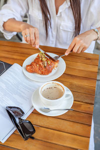 Midsection of woman having food on table