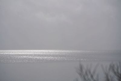 Close-up of snow on beach against clear sky