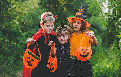 Happy boys and girls wearing costume standing in park