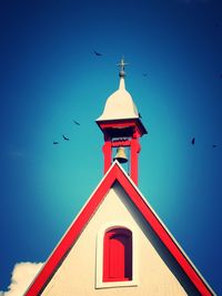 Low angle view of bird flying against blue sky