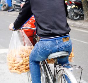 Rear view of man with bicycle on street