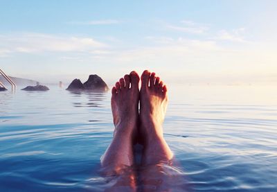 Low section of woman relaxing in swimming pool