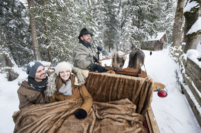 Couple enjoying a ride in a horse-drawn sleigh in winter