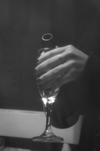 Close-up of hand holding wine glass on table