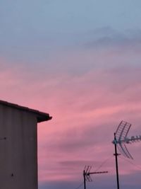 Low angle view of silhouette cranes against sky during sunset