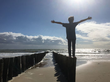Low angle view of man standing on beach against sky
