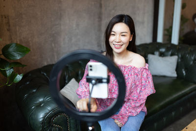 Smiling woman vlogging at studio