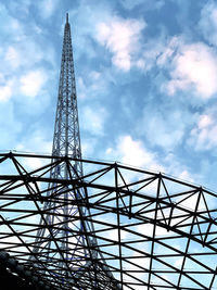 Low angle view of ferris wheel against cloudy sky