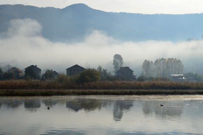 Scenic view of lake by mountains against sky