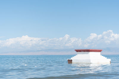 Lifeguard hut on sea against blue sky