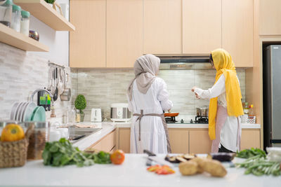 Woman standing on cutting board in kitchen