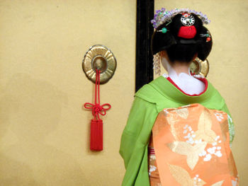 Rear view of geisha walking towards door