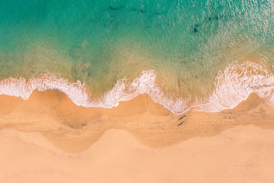 Aerial view of atlantic ocean coast with crystal clear turquoise water, waves rolling into the shore