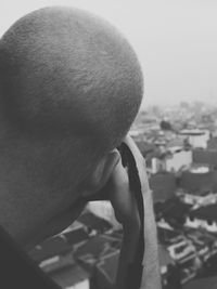 Man photographing through camera against sky