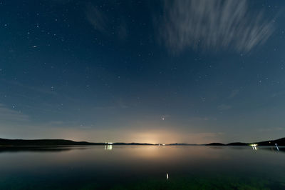 Scenic view of lake against sky at night