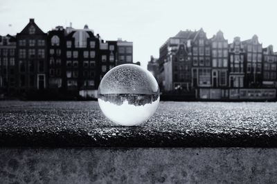 Close-up of crystal ball on building against sky