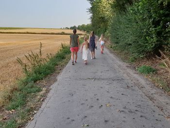 Rear view of women walking on road