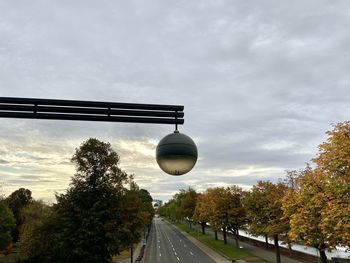 Road by trees against sky