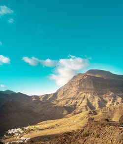 Scenic view of mountains against blue sky