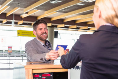 Male traveler giving passport to hostess