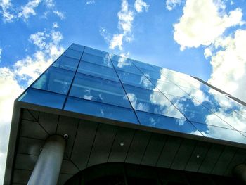 Low angle view of clouds reflection on modern glass building
