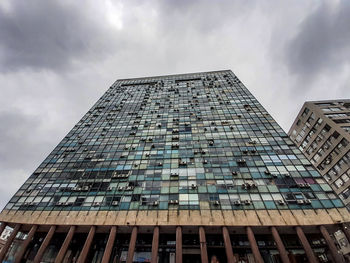 Low angle view of modern building against cloudy sky