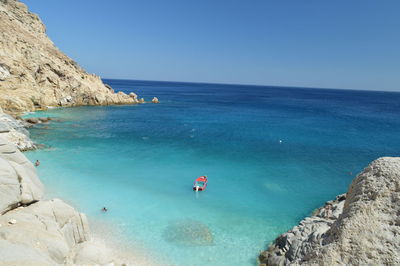 High angle view of red boat in blue sea against clear sky on sunny day