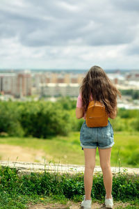 Rear view of woman standing on field