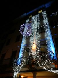 Low angle view of illuminated lighting equipment at night