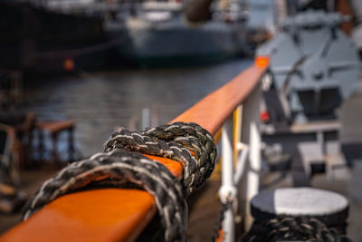 Close-up of rope tied on railing in ship