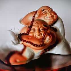 Close-up of laughing buddha figurines at home