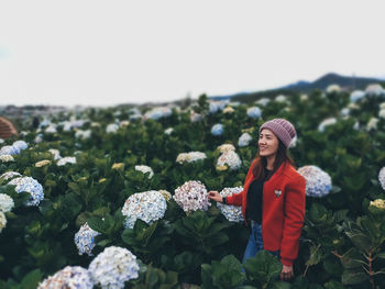 Woman standing by plants against sky